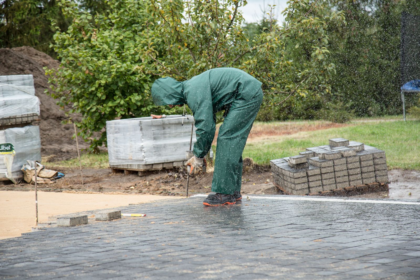 A groundworks contractor laying block paving on a driveway